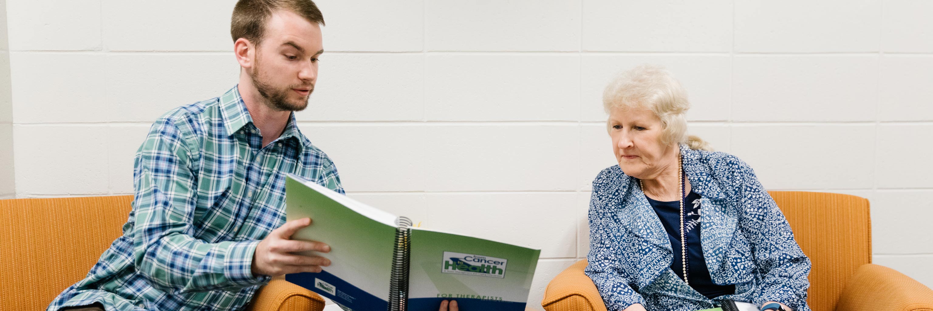 man showing an older lady a book